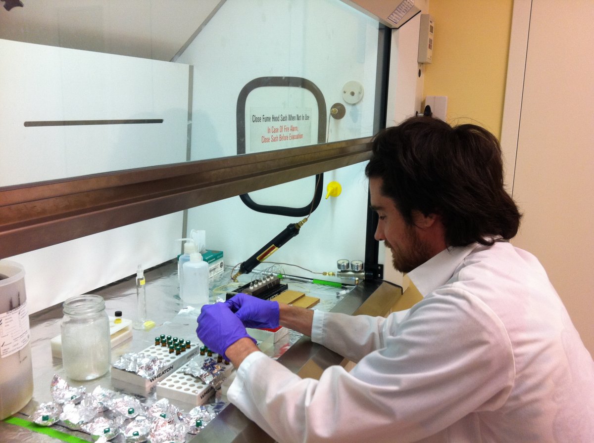 Lab tech seated at lab bench handling test tubes