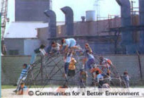 Children playing on playground in front of a factory