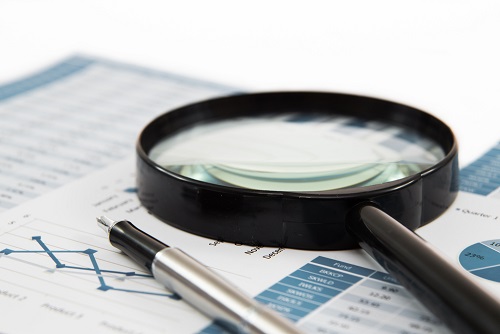 Magnifying glass over a paper showing graphs